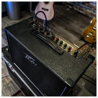 Guitar amplifier with control panel on a wooden floor