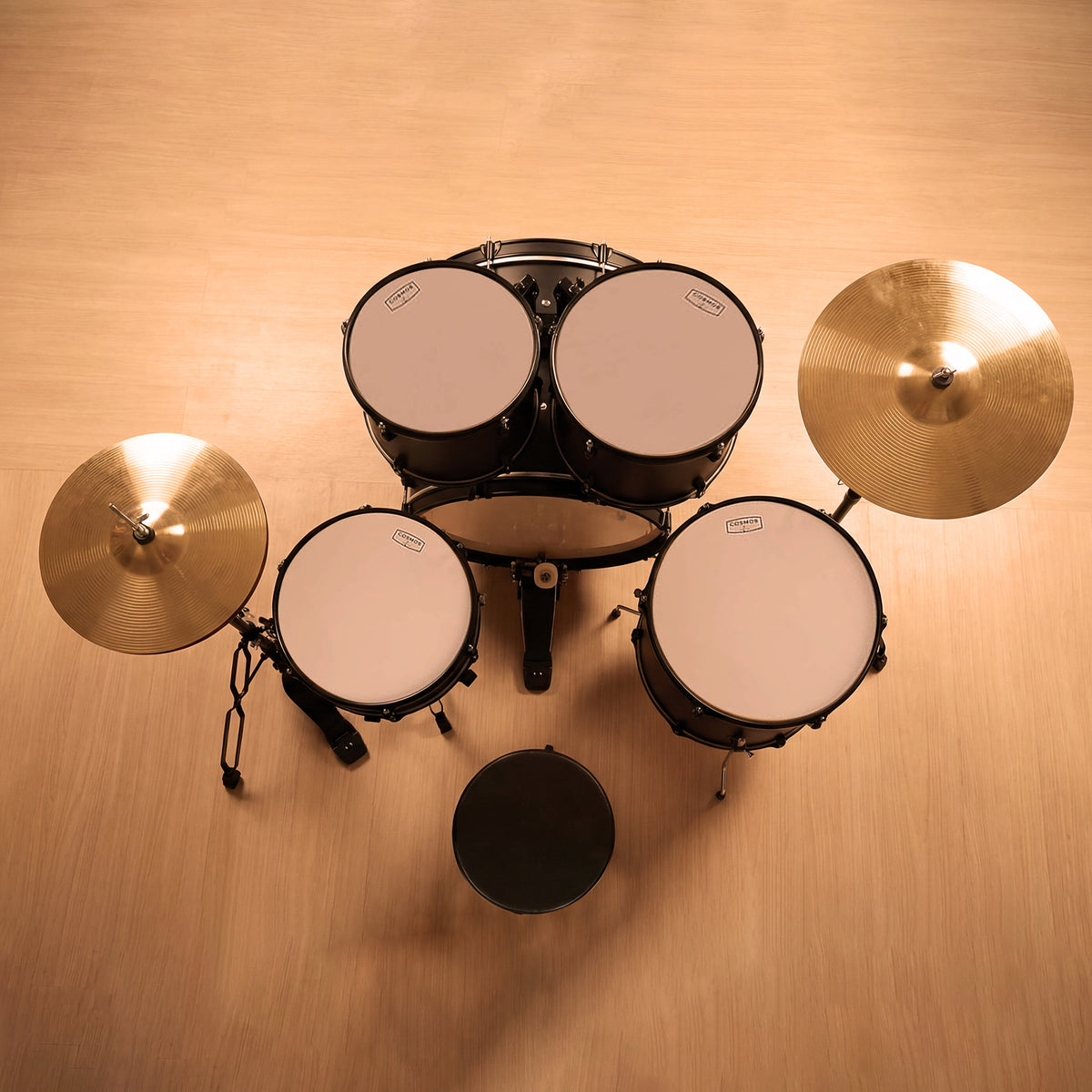 Profile view of a black acoustic drum set, focusing on the heavy-duty double-braced hardware stands, foot pedals, and cymbal placements.