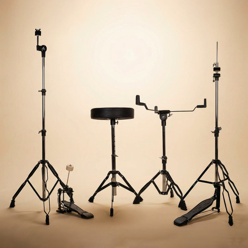 Behind-the-kit view of a black acoustic drum set, showcasing the layout from a drummer's perspective, including the snare stand, kick pedal, and drum throne.