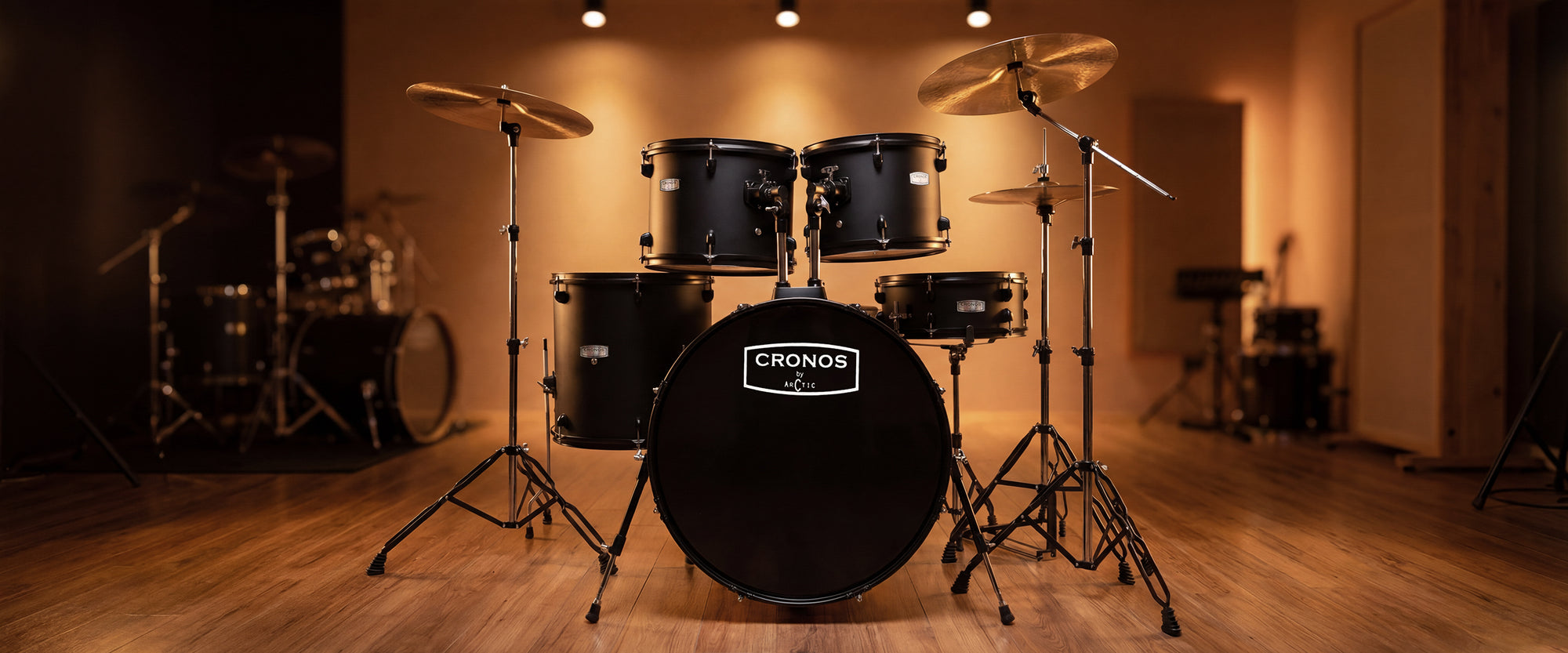 Three-quarter angled desktop shot of a black acoustic drum kit, highlighting the configuration of the rack toms, floor tom, and hardware.