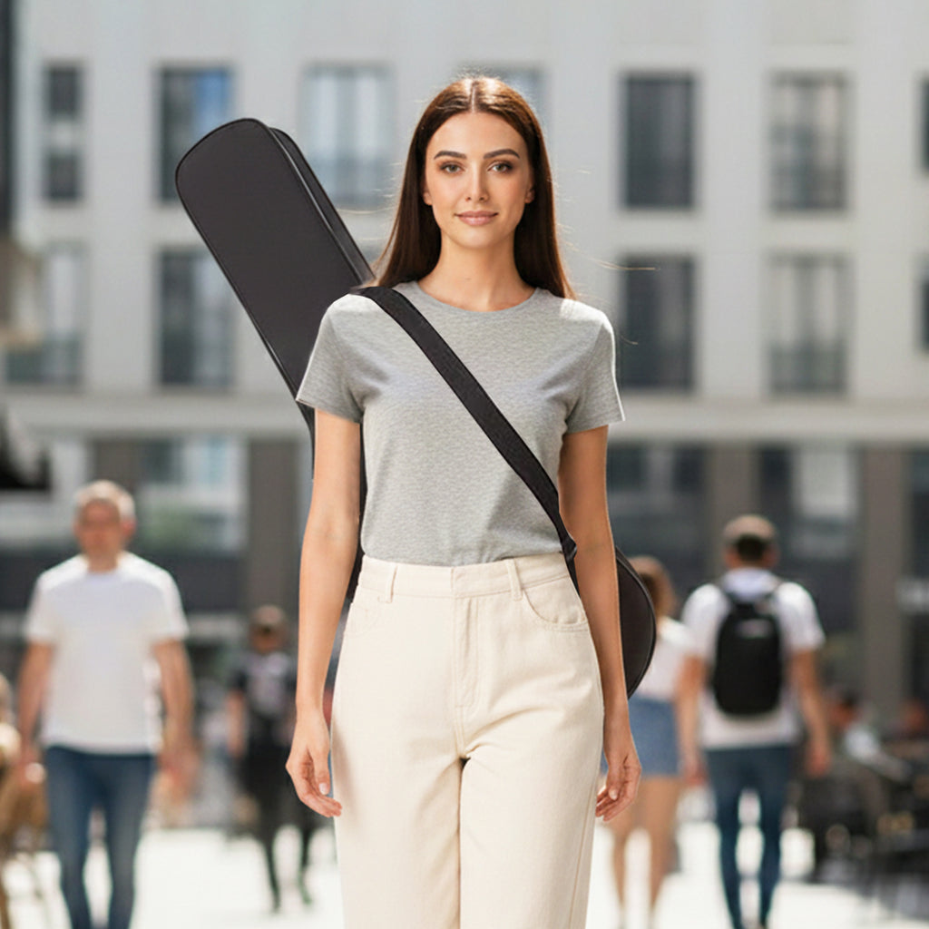 Woman holding a guitar case on a city street