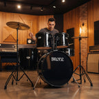 Person playing a drum set with 'Bronz' branding in a studio setting.