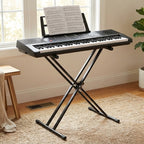 Keyboard with music stand in a room with a window and plant