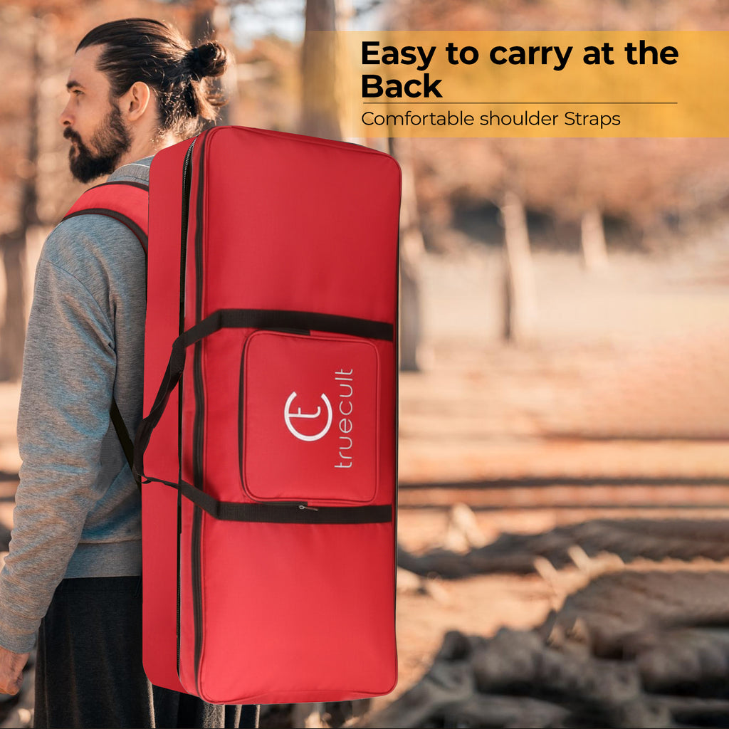 Person carrying a red bag with 'truecult' branding on a blurred natural background padded 61-key keyboard bag for Yamaha Casio