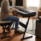Guitar World Store black heavy-duty Z-style adjustable keyboard stand supporting an 88-key digital piano.